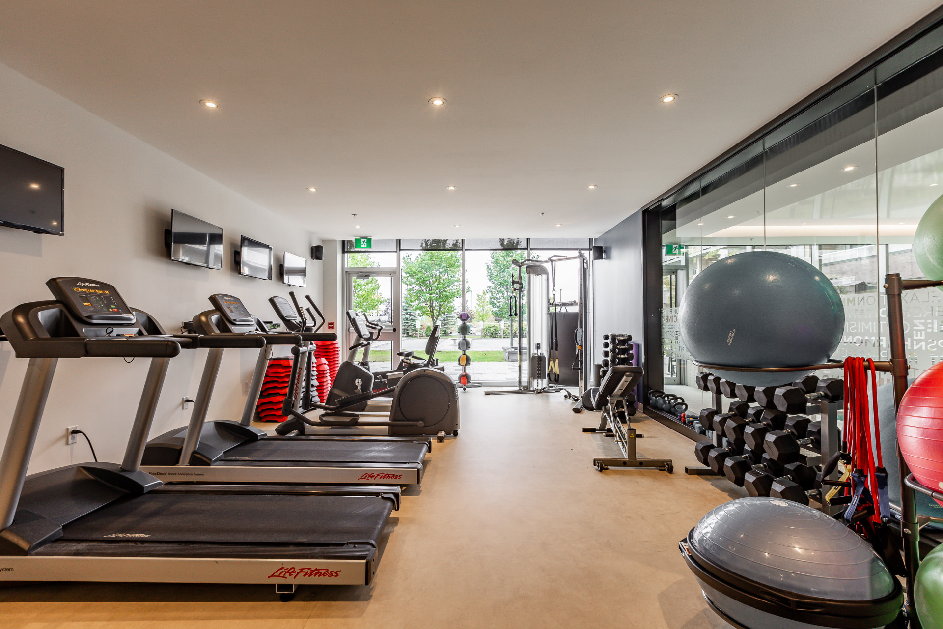 Salle d'entraînement avec tapis roulants et poids libres