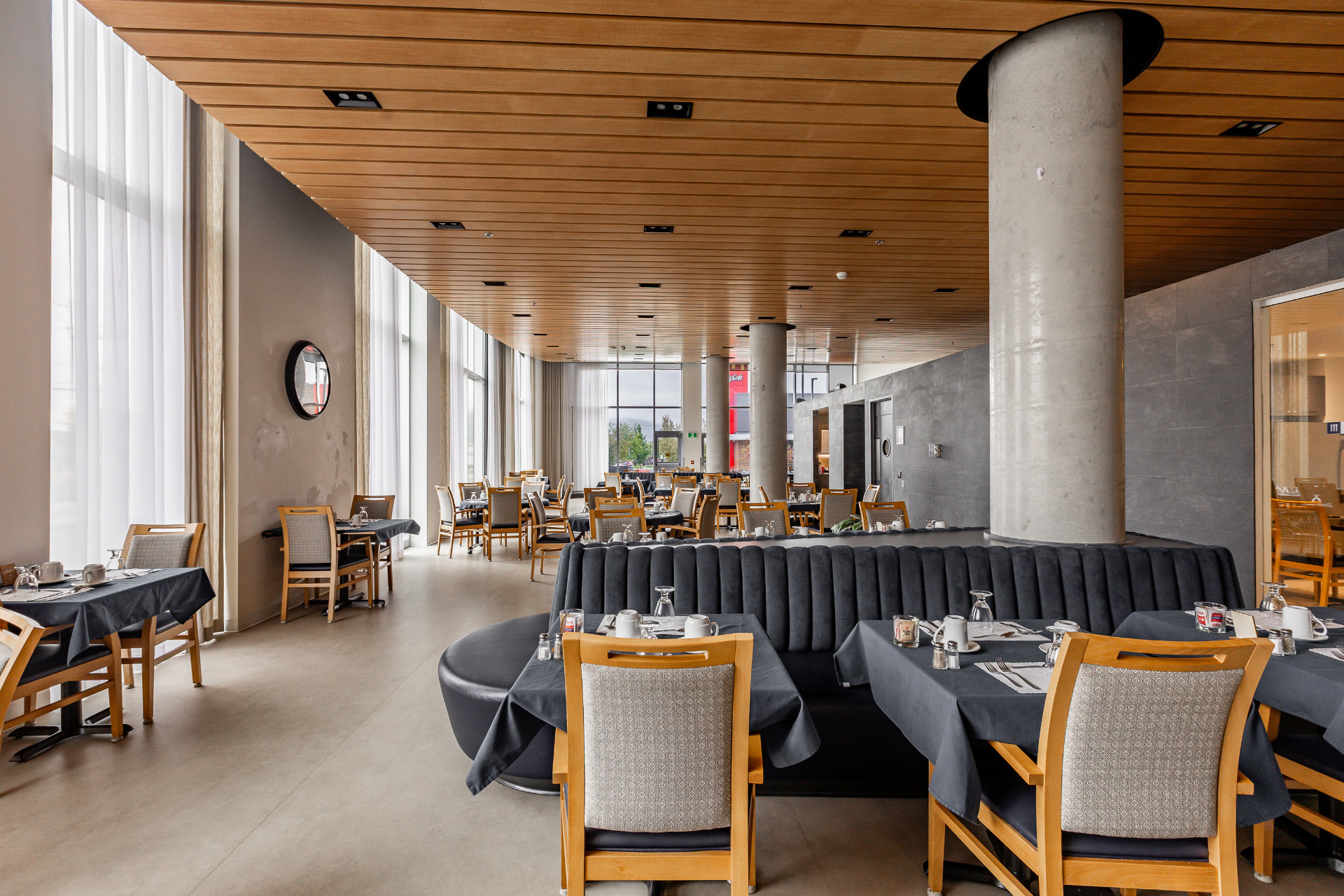 Salle à manger avec plafond de bois et grandes fenêtres