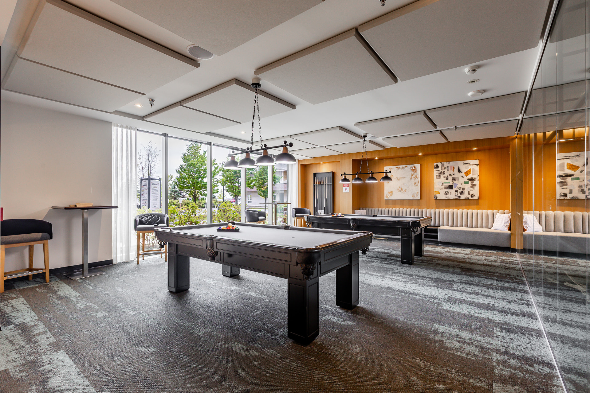 Salle de billard avec deux tables et coin détente