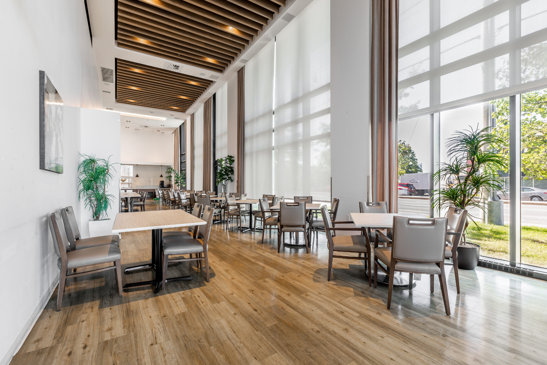 Grande salle à manger aux plafonds de bois et fenêtres du sol au plafond